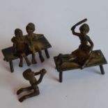 Three unusual early 20th century painted bronze miniature figures: a couple seated on a bench, a