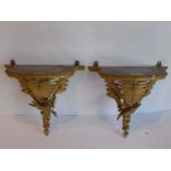 An opposing pair of late 19th century gilt-gesso and ebonised wall brackets; decorated in relief