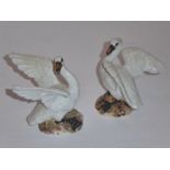 A pair of 19th century Meissen porcelain models of open-winged swans; blue-painted crossed swords