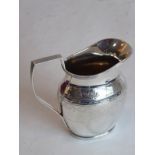 A late 19th century hallmarked silver cream jug in late 18th century style; high reeded edge