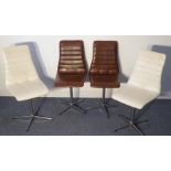 A set of four (two in brown upholstery, two in white) designer swivel chairs; each on circular