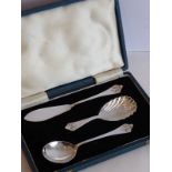 A cased three-piece silver set comprising butter knife, caddy spoon and small serving spoon,