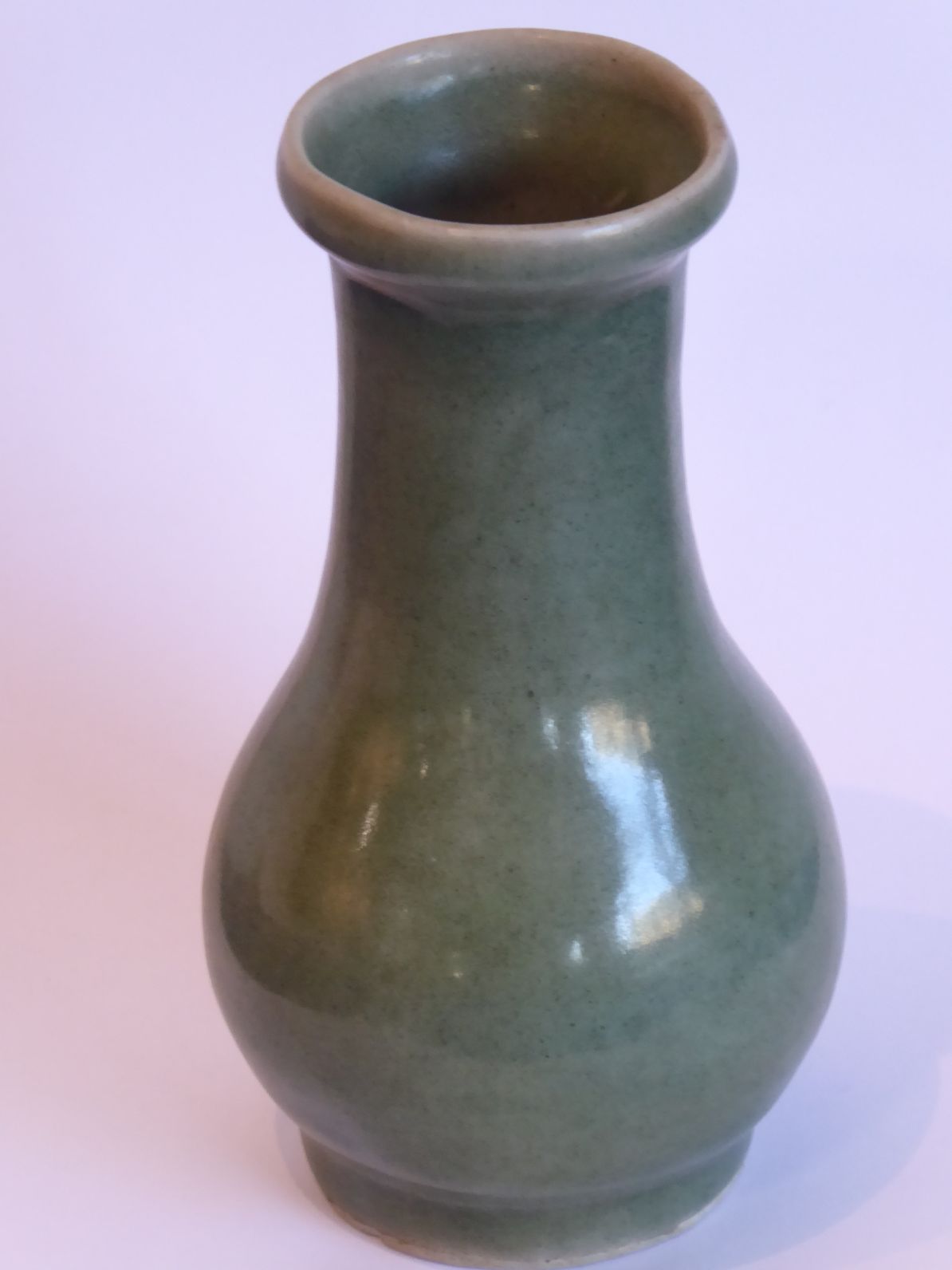 A Chinese Southern Song period small celadon glaze bottle vase; the lip above a slightly tapering