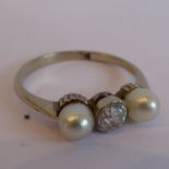 A white-metal dress ring (cut and re-affixed) centrally set with a diamond flanked by two pearls,