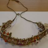 An Indian yellow-metal fringe necklace set with a multitude of semi-precious stones, coral etc., and