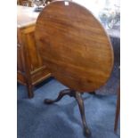 A mid 18th Century circular tilt top mahogany occasional table, the one piece top above gun barrel