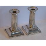 A pair of dwarf silver table candlesticks; modelled in the classical style with fluted and reeded