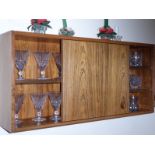 A 1960's/70's Scandinavian style wall mounted rosewood cabinet having shelves and single sliding