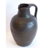 A brown earthenware jug (possibly early English) (23 cm high)