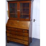 An 18th Century mahogany bureau cabinet, dentil cornice above two glazed doors enclosing shelves and