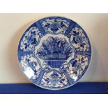 An 18th century Delftware charger hand-decorated in cobalt-blue with a central flower basket and six