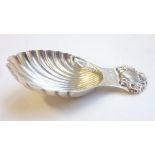 A modern hallmarked silver caddy spoon in the shape of a scallop shell