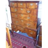 An 18th century walnut chest-on-stand; cross-grained cornice above three small drawers and three