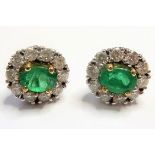 A pair of 18 carat emerald and diamond ear studs