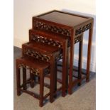 A nest of four early 20th century Chinese hardwood occasional tables; each with decorative carved