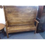 An early 18th century elm monk's bench, the patinated planked table top rotating on iron pegs to