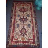 A flat-weave tribal rug decorated with a red and a blue symbol above a lozenge shape with stylised