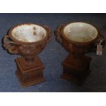 A pair of early 20th century cast-iron urns in the Classical style and after the antique; each