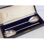 A cased pair of hallmarked silver salad servers marked Finnigans, assayed Birmingham 1909 (approx