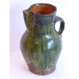 A green-glazed two-handled pottery jug (possibly early English) (24cm)