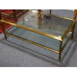 A modern rectangular bronzed designer coffee table with glass top and conforming undertier, raised