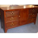 An early 19th century mahogany dresser base, the figured overhanging top above a central panelled