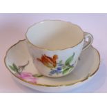 A late 19th/early 20th century Meissen porcelain cup and saucer; hand-decorated with flowers and