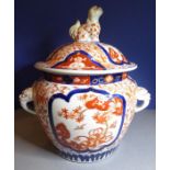 A 19th century porcelain Imari-style jar and cover, red and blue design with mask handles and dog of