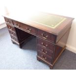 A green leather-topped reproduction mahogany pedestal desk