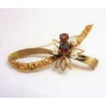 A 9-carat yellow-gold brooch set with three pearls and two garnets against a textured ribbon