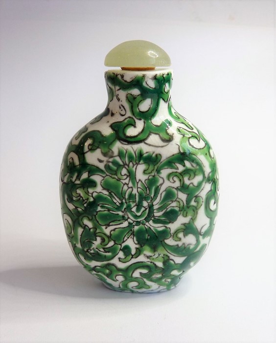 A Chinese porcelain snuff bottle having a green hardstone stopper and decorated in the famille-verte