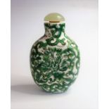 A Chinese porcelain snuff bottle having a green hardstone stopper and decorated in the famille-verte