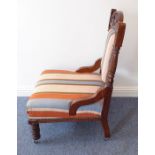 A late 19th century carved walnut and upholstered low nursing chair; large turned front legs