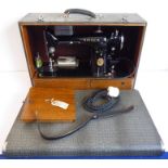 A cased Singer sewing machine with accessoriesThe sewing machine looks to be in good overall general
