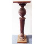 A mahogany torchère having bulbous turned and fluted stem