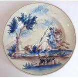 A 19th century Delftware dish hand-decorated with a mounted male figure about to spear a chasing