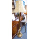 A gilt-wood lamp standard with extravagant tasselled shade; the fluted stem above a stiff plantain-