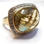 A heavy 9-carat gold ring set with large citrine and diamond border (The cost of UK postage via