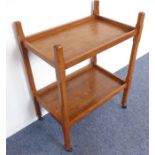 An Arts & Crafts style two-tier oak tea trolley with chamfered uprights