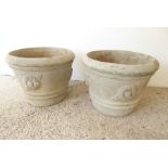 A large pair of circular, verdigrised stoneware garden planters; each embossed with flower-head
