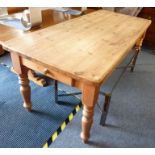 A 19th-century-style pine kitchen table with single end-drawer and raised on turned tapering legs (