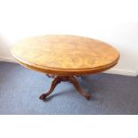 A mid-19th century oval figured walnut-topped loo table; turned stem carved with foliate designs