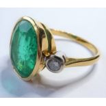 An 18-carat gold ring with central 6-carat emerald flanked by two diamonds, ring size S/T (The