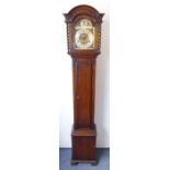 A 1930s oak-cased grandmother clock; the broken-arch dial with silvered chapter dial with Roman