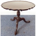 A mahogany tilt-top occasional table, pie-crust edge top above turned stem and three downswept