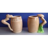 A pair of early 20th century barrel-shaped pottery mugs having 'risqué' handles