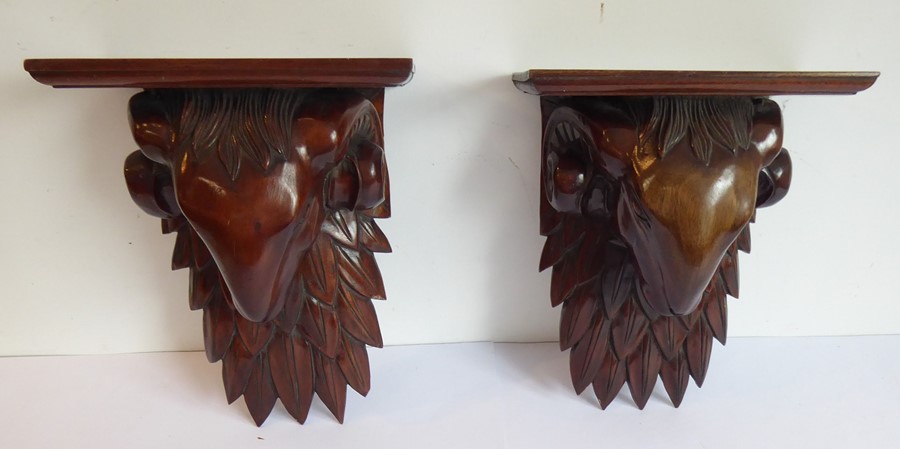 A pair of carved wood wall brackets modelled as ram's heads in Robert Adams style (32cm high)