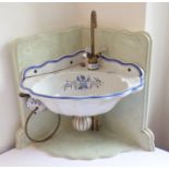 A 19th century style ceramic corner sink unit with brass taps