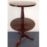 A two-tier circular mahogany dumb waiter on tripod base