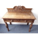 A 19th century carved oak side table, the galleried back centred with the 'green man' flanked by